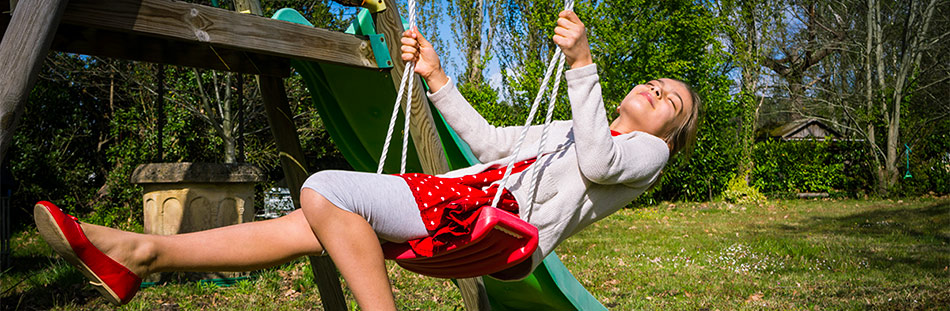 Enfant sur balançoire rouge