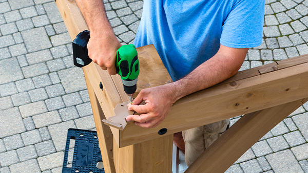 fixation des traverses sur une pergola adossée